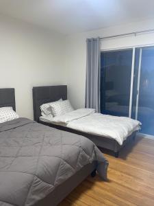 two beds sitting in a room with a window at Home in West Vancouver in West Vancouver