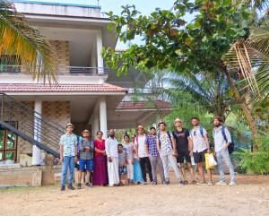 a group of people standing in front of a house at Munroe La Casa in Kollam
