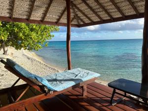 a bench on a porch looking at the beach at Rangiroa Bliss in Tiputa
