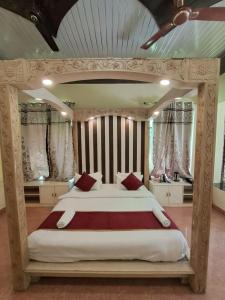 - une grande chambre avec un grand lit et des oreillers rouges dans l'établissement Hotel Bhajgovindam, à Haridwar