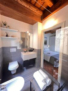 a bathroom with a sink and a toilet and a bed at CASA DI MILO in Cernobbio