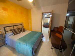 聖馬丁德拉維加的住宿－Casa Pumba，一间卧室配有一张床、镜子和椅子
