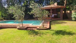 a swimming pool in a yard with a house at Secret guest house in Pietermaritzburg