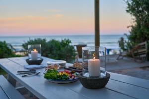 a picnic table with candles and a plate of food at Soul Searchers in Jeffreys Bay