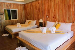 1 dormitorio con 2 camas y toallas. en กอบสุข รีสอร์ท2 k03, en Ban Ton Liang