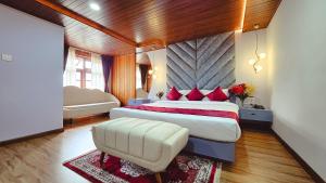 1 dormitorio con 1 cama grande con almohadas rojas en Sumi Stays, en Bijanbāri Bāzār