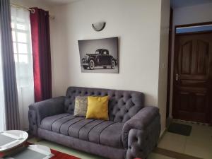 - un salon avec un canapé et une voiture sur le mur dans l'établissement macdade apartment, à Nairobi