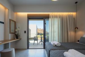 a bedroom with a bed and a view of a balcony at New Modern Villas with Private Pools and Walking distance to Beach in Panormos Rethymno