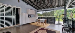 a kitchen with a table and chairs and large windows at Tambun Hillview Cottage 1 in Tambun