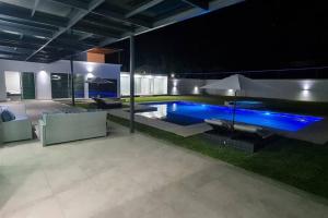 uma casa com piscina à noite em Casa de Lujo/10 minutos Estacas/ Cancha Frontón em Ticumán