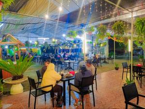 a group of people sitting at a table in a restaurant at TERENGGANU EQUESTRIAN RESORT (PADDOCK INN) in Kuala Terengganu