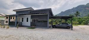 a black car parked in front of a house at Tambun Hillview Cottage in Tambun