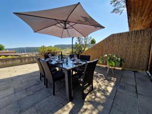 una mesa con sombrilla en el patio en Große Terrasse, Netflix, 5min zum Skilift, 6 Personen, Waldnah, en Schonach