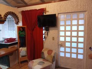 a woman is standing in a room with a television at Villa Cholula in Cholula