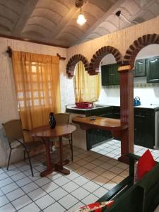 una cucina con armadi verdi, tavolo e sedie di Villa Cholula a Cholula