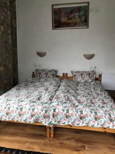 um quarto com uma cama com um edredão floral em Лилянината къща em Kalofer