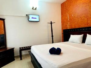 a bedroom with a bed with a tv on the wall at Grand Crown Hotel in Anuradhapura