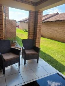 two chairs sitting on a patio with a yard at Adante @ Midrand in Midrand