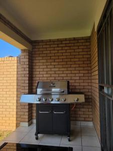 a grill on a patio with a brick wall at Adante @ Midrand in Midrand