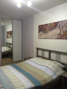 a bedroom with a bed and a painting on the wall at Metro Krasny Prospekt Apartment in Novosibirsk