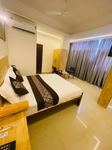 a bedroom with a bed and a large window at RAINBOW ROOMS in Kozhikode