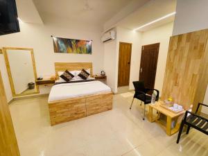 a bedroom with a bed and a table and a desk at RAINBOW ROOMS in Kozhikode