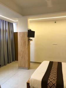 a hotel room with a bed and a flat screen tv at RAINBOW ROOMS in Kozhikode