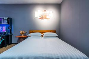 a blue bedroom with a large bed with two pillows at Chengdu Dreams Travel International Youth Hostel in Chengdu