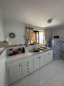 La cuisine blanche est équipée d'un évier et d'un réfrigérateur. dans l'établissement Pleasant Studio In Casablanca, à Casablanca