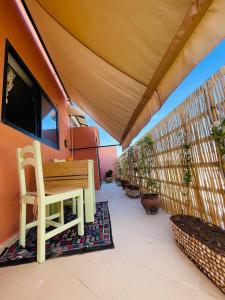 un banc en bois sur un balcon orné de plantes dans l'établissement Pleasant Studio In Casablanca, à Casablanca