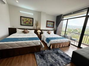 een slaapkamer met twee bedden en een groot raam bij Trang An Royal Bungalow in Ninh Binh +49 foto's