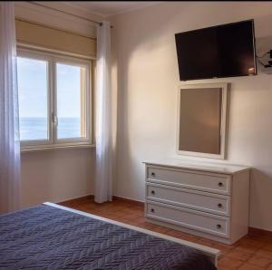 a bedroom with a dresser with a flat screen tv at casavacanzabordonaro in Palermo