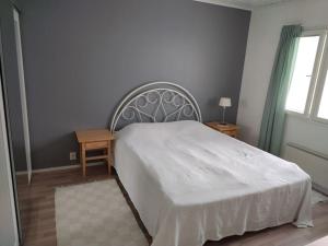 a bedroom with a white bed and a window at Talo 140 m2 in Siilinjärvi