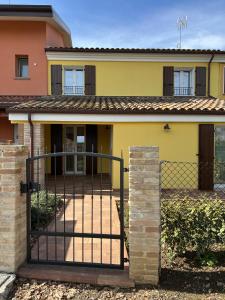 a yellow house with a gate in front of it at Casa sul Conca in San Giovanni in Marignano