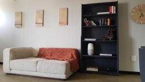 a living room with a couch and a book shelf at Ietzie Longbeach in Swakopmund