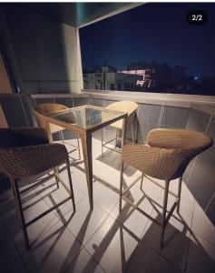 d'une table et de chaises en verre sur le balcon. dans l'établissement Express Square9, à Gurgaon