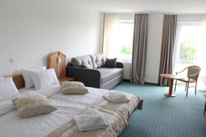ein Hotelzimmer mit 2 Betten und einem Sofa in der Unterkunft Hotel Bessunger Forst in Roßdorf