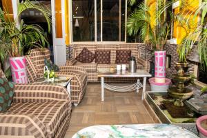 eine Terrasse mit Sofas, einem Tisch und Pflanzen in der Unterkunft The Elite Apartment Hotel in Kalkutta