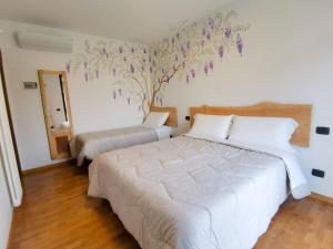 a bedroom with two beds with purple flowers on the wall at B&B Ca' Restom in Reggio Emilia