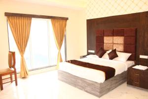 ein Schlafzimmer mit einem großen Bett und einem großen Fenster in der Unterkunft SAS SQUARE in Tiruchchirāppalli