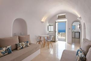 a living room with a couch and a table at SEACREST VILLA-VOLCANO VIEW in Oia