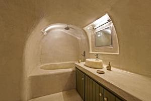 a bathroom with a sink and a bath tub at SEACREST VILLA-VOLCANO VIEW in Oia