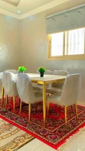 una sala da pranzo con tavolo e sedie su un tappeto di Madinah Daylight Residences a Medina