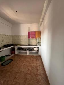 una cocina vacía con armarios rosados y suelo de madera en One room with kitchen, WiFi and washing machine, en Bangalore