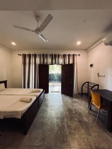 um quarto com 2 camas, uma mesa e uma janela em Green Corridor - Ahangama em Ahangama