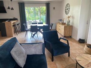 salon z kanapą, stołem i krzesłami w obiekcie Les Ecrehous de Saint Jean w mieście Barneville-Plage
