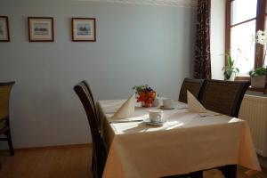 a table with a white table cloth on it at Pension Kramerhof in Taufkirchen
