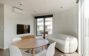 惠靈頓的住宿－Brand new Wellington Central Apartments by CP collective，客厅配有桌子和白色椅子