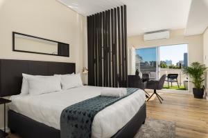 a hotel room with a bed and a balcony at 220 On Loop Luxury Apartments in Cape Town