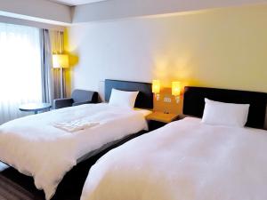 大阪市にあるプリンス　スマート　イン　大阪淀屋橋のベッド2台と窓が備わるホテルルームです。